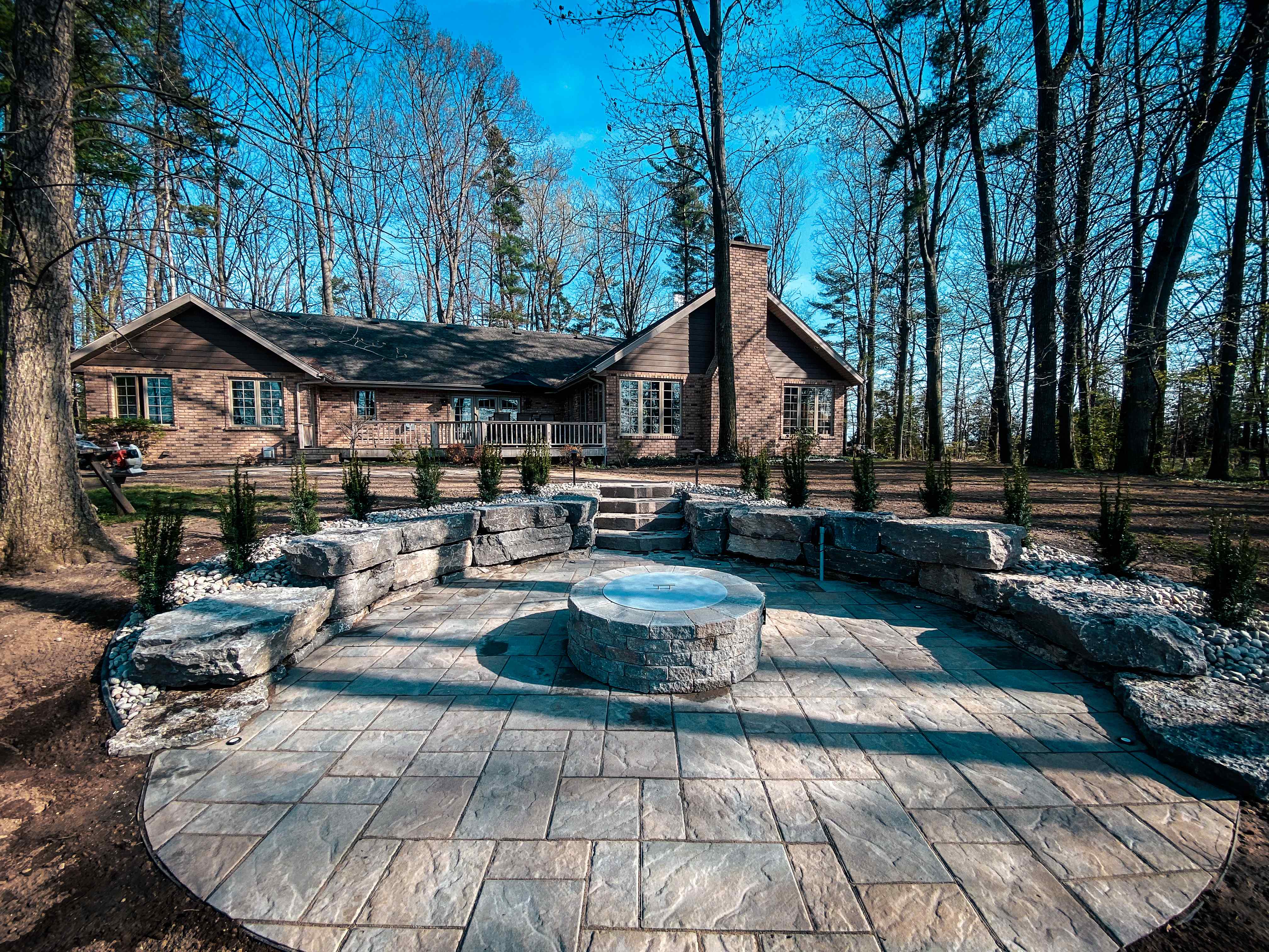 Natural stone fire pit with circular paved design