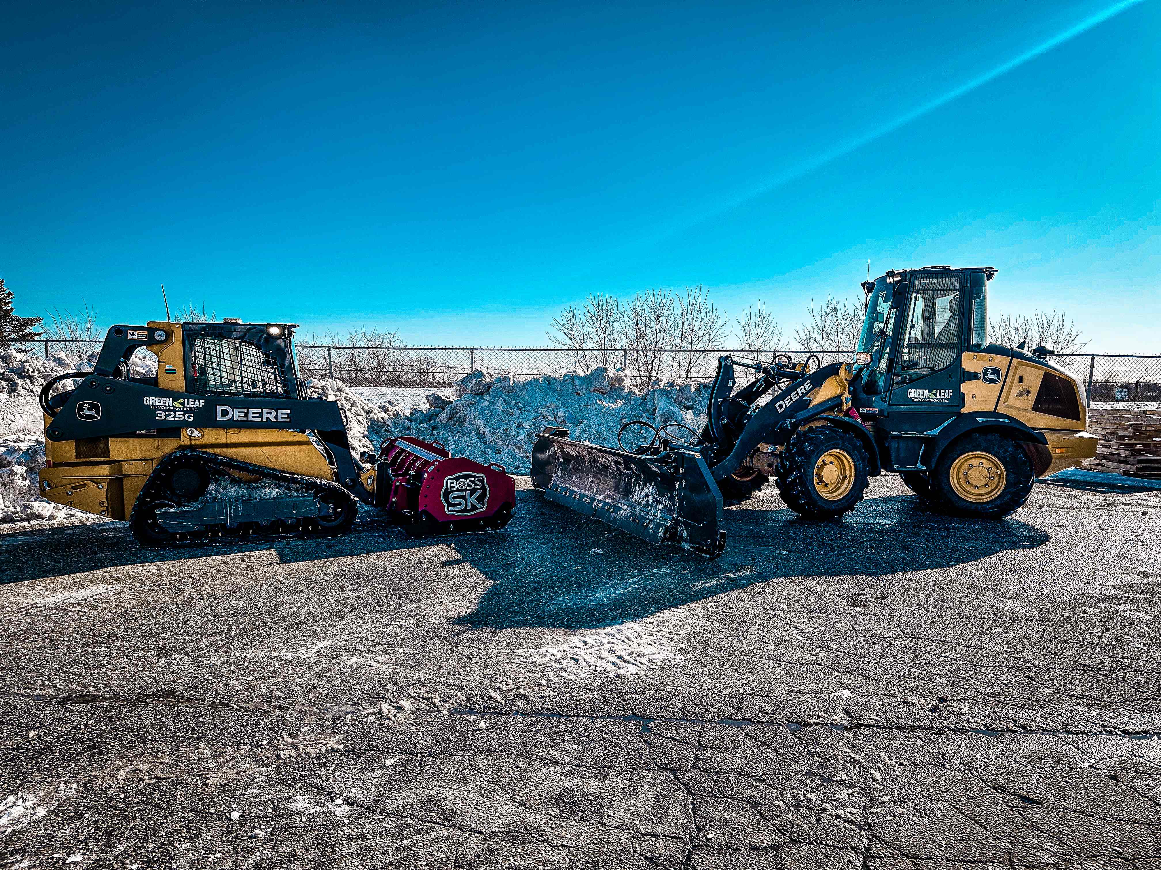 Green Leaf John Deere skid steer and wheel loader with snow plowing equipment